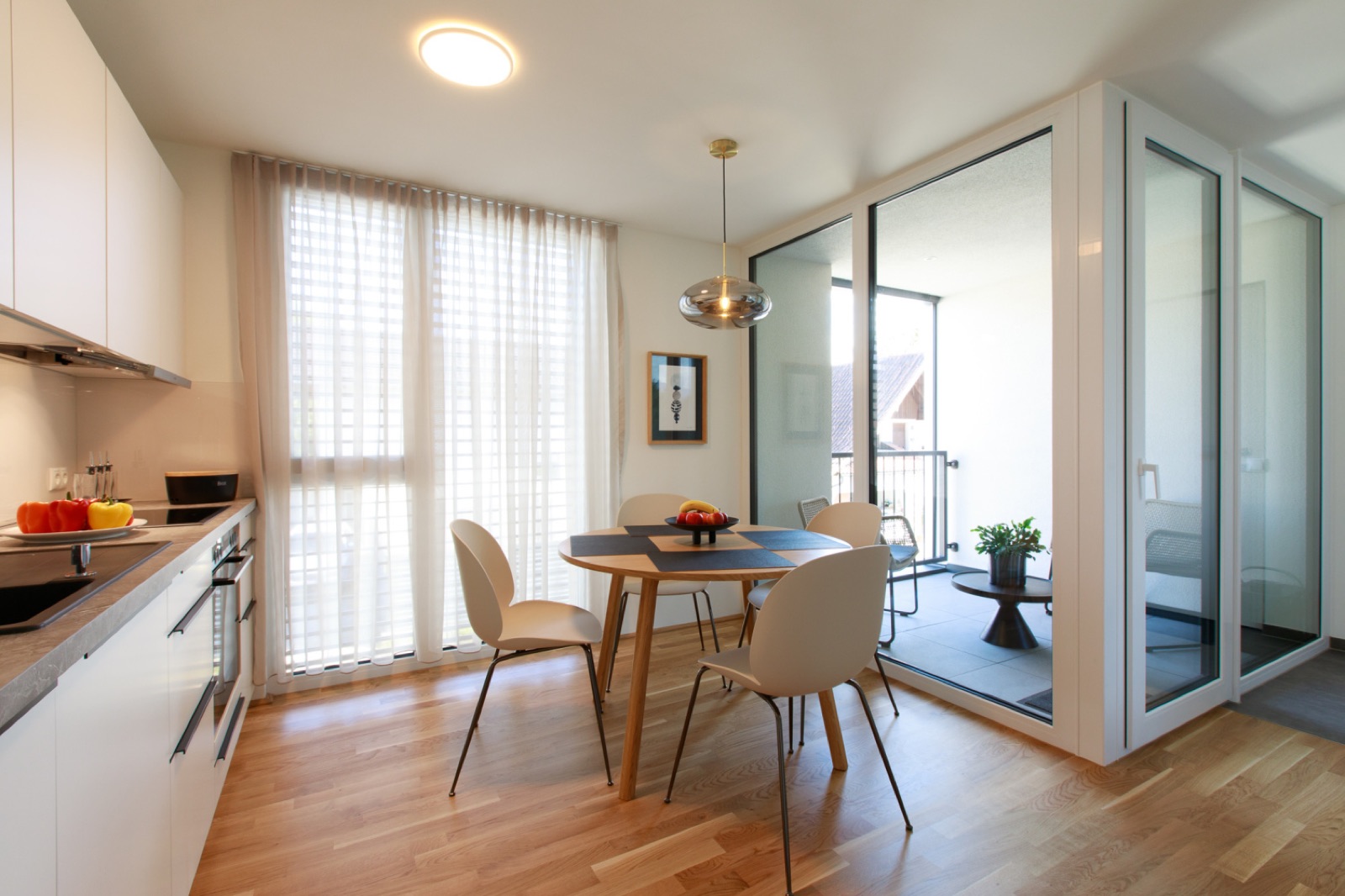 Essbereich mit Küche und Blick auf den Balkon im Wohlfühlapartment in Hard / Top 1