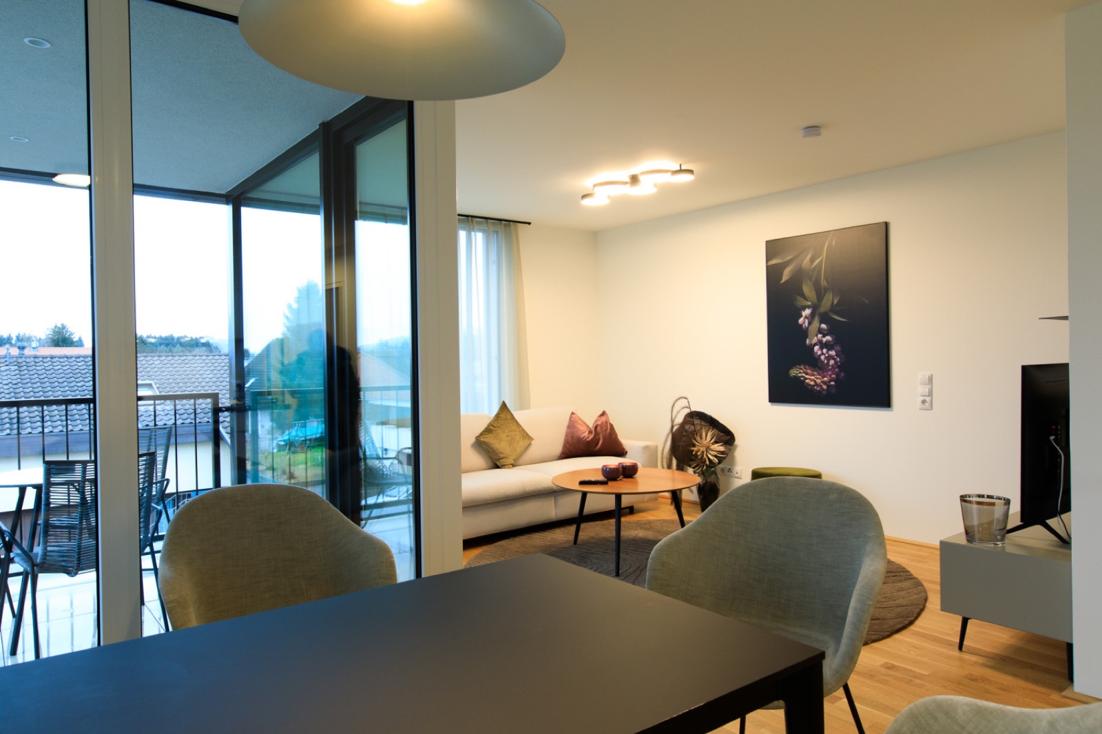 Wohnbereich mit Essplatz und Balkon im Wohlfühlapartment in Hard