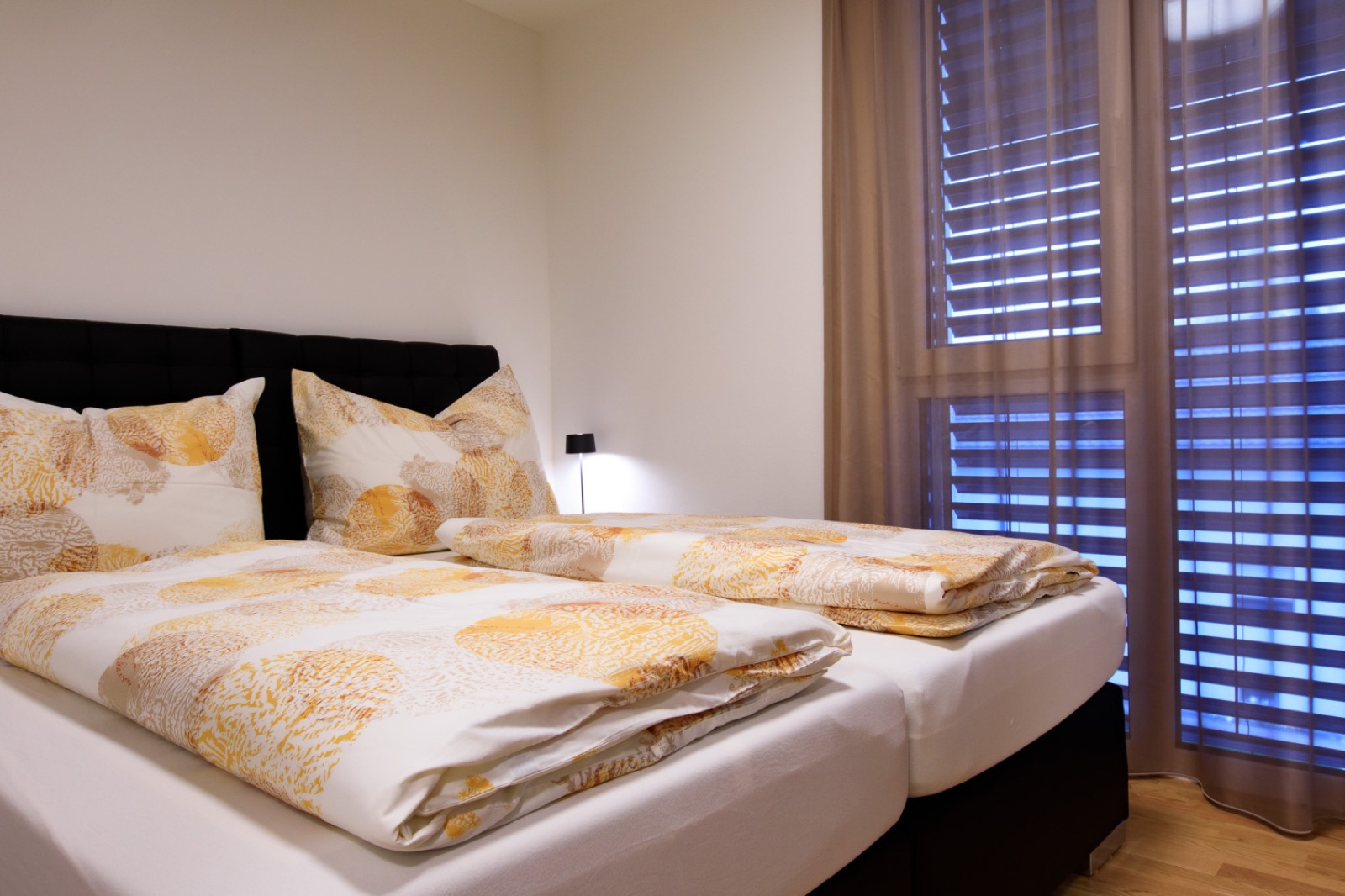 Schlafzimmer mit Doppelbett und Vorhängen in Hard / Top 8