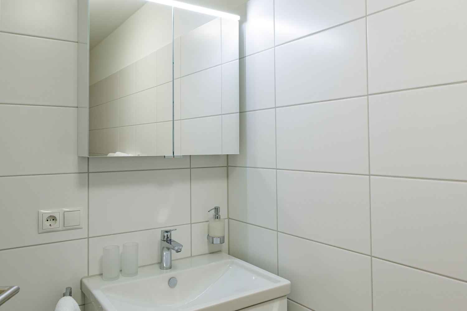 Badezimmer mit Waschtisch und Spiegelschrank in Hard / Top 8